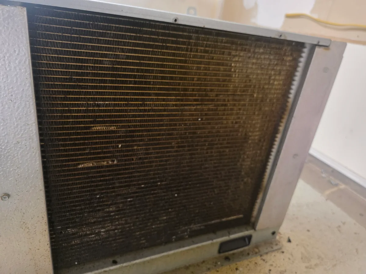 Dust buildup on the condenser coil of a commercial walk-in freezer in Manhattan Beach, CA