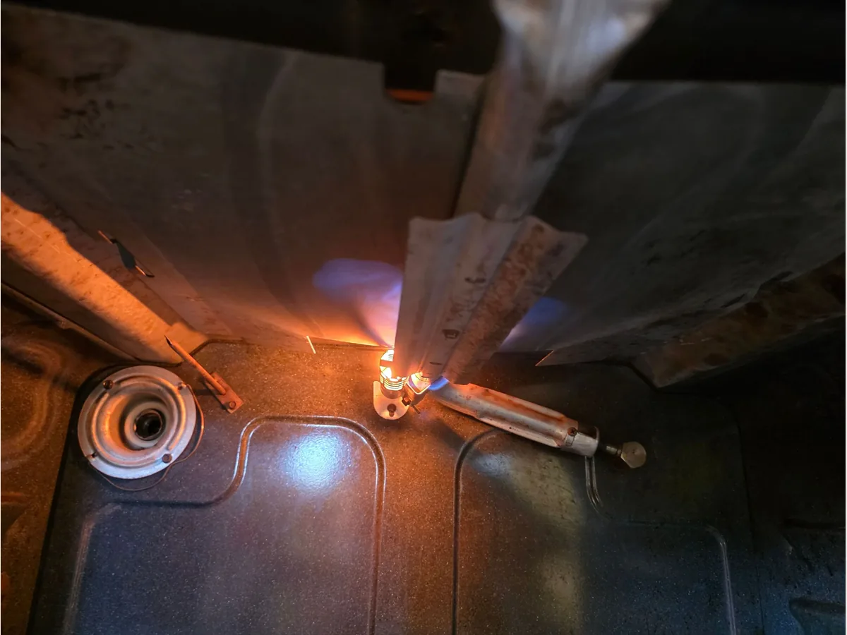 Igniter glowing at the lit burner inside a gas oven